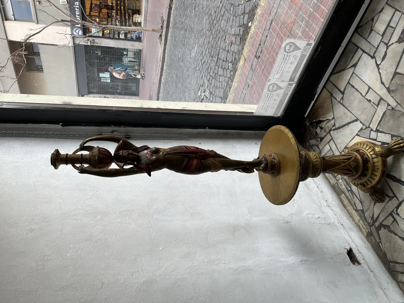 Scultura antica di una donna che tiene una lampada in un ambiente elegante.