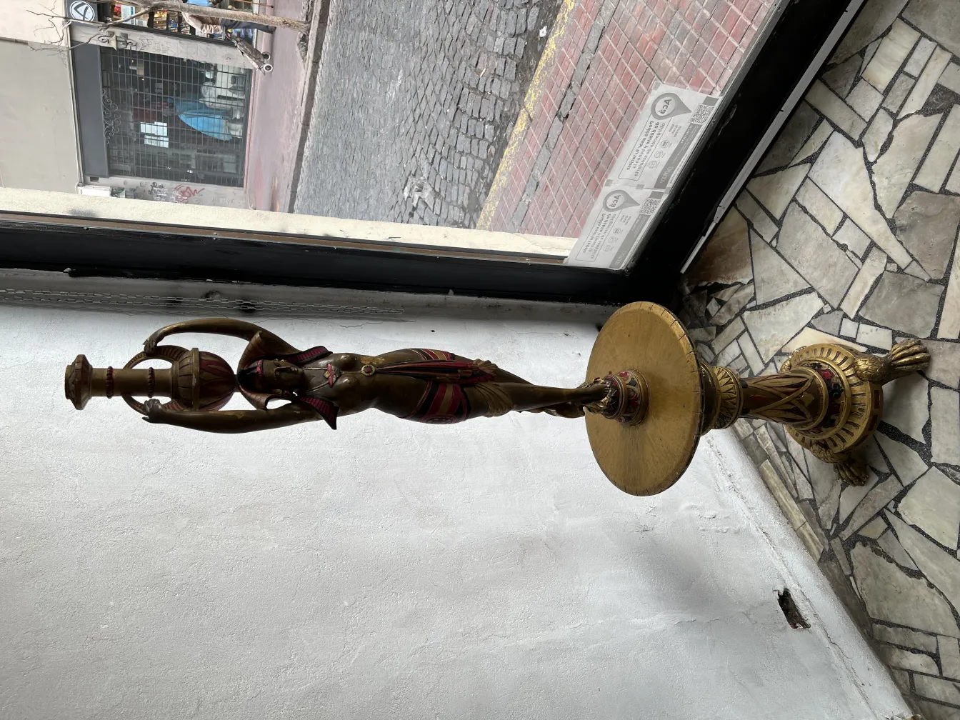 Antike Skulptur einer Frau mit einer Tasse und dekorativen Details.