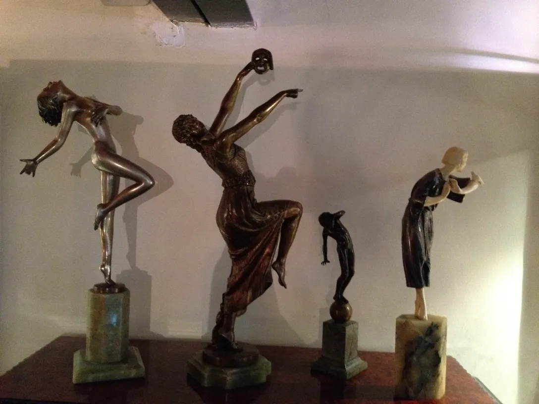 three antique sculptures of human figures on display