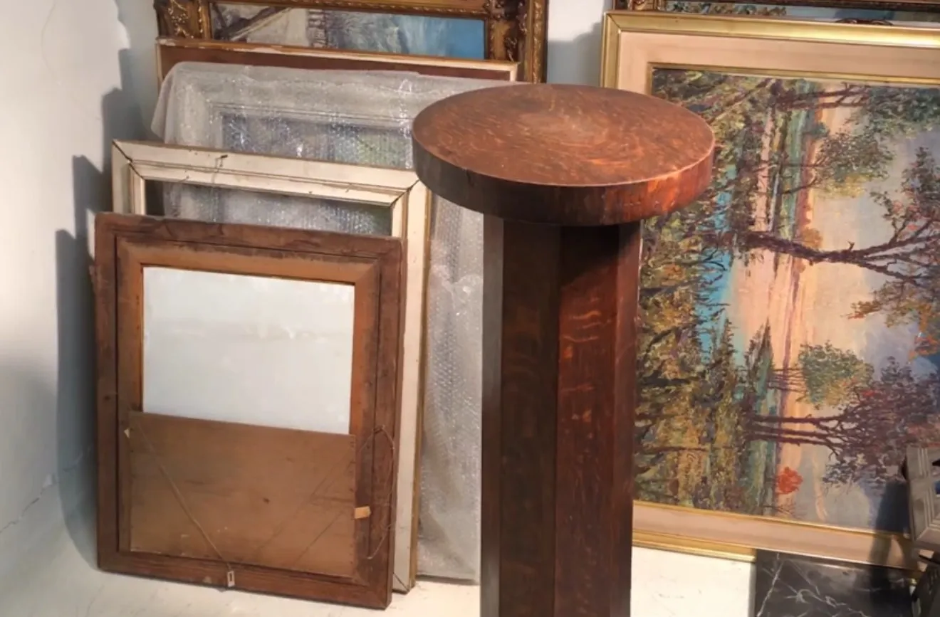 Colonne ancienne en bois, parfaite pour la déco. Arrière-plan avec des tableaux et des miroirs.