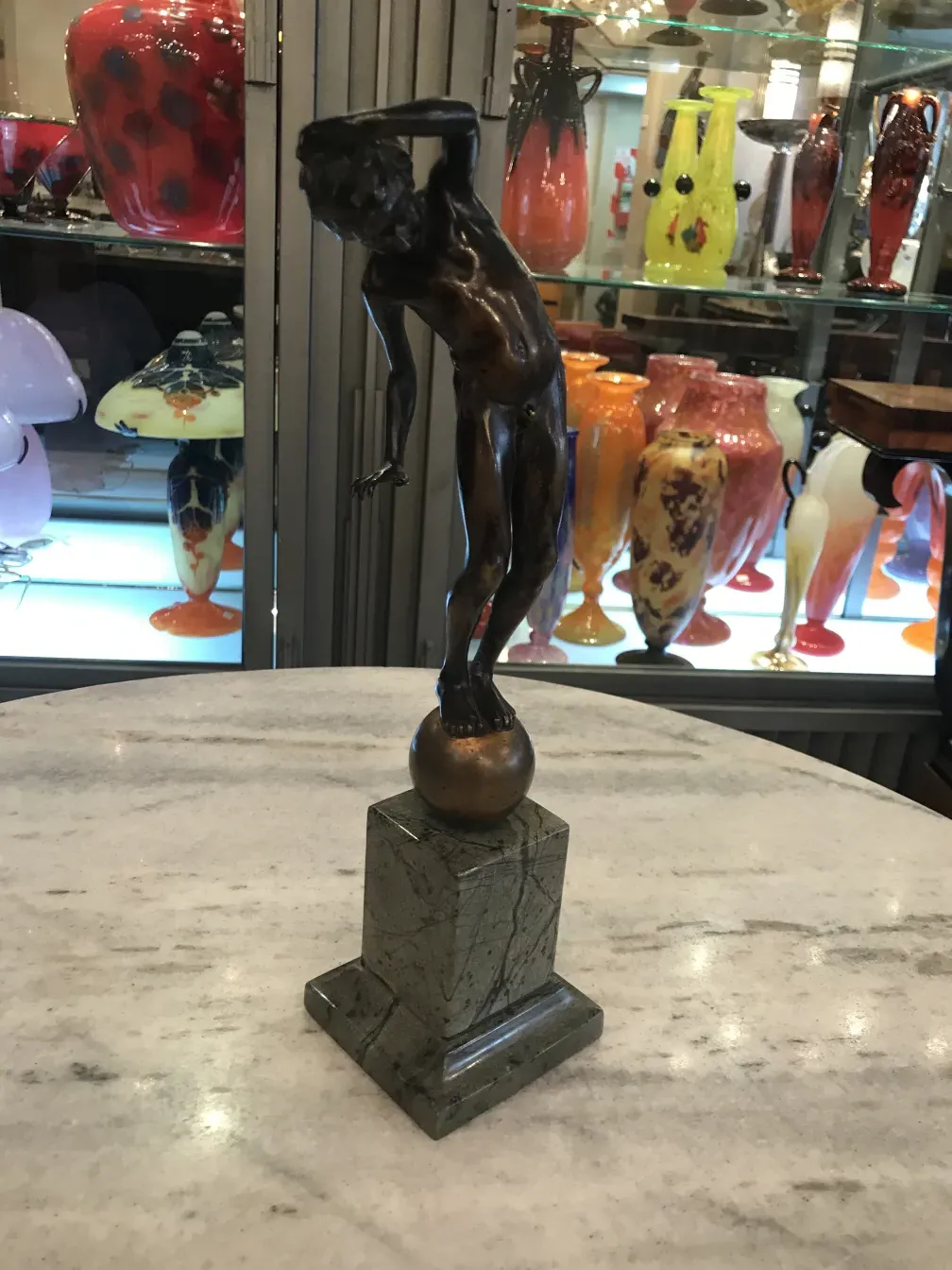escultura antiga de bronze sobre base de pedra