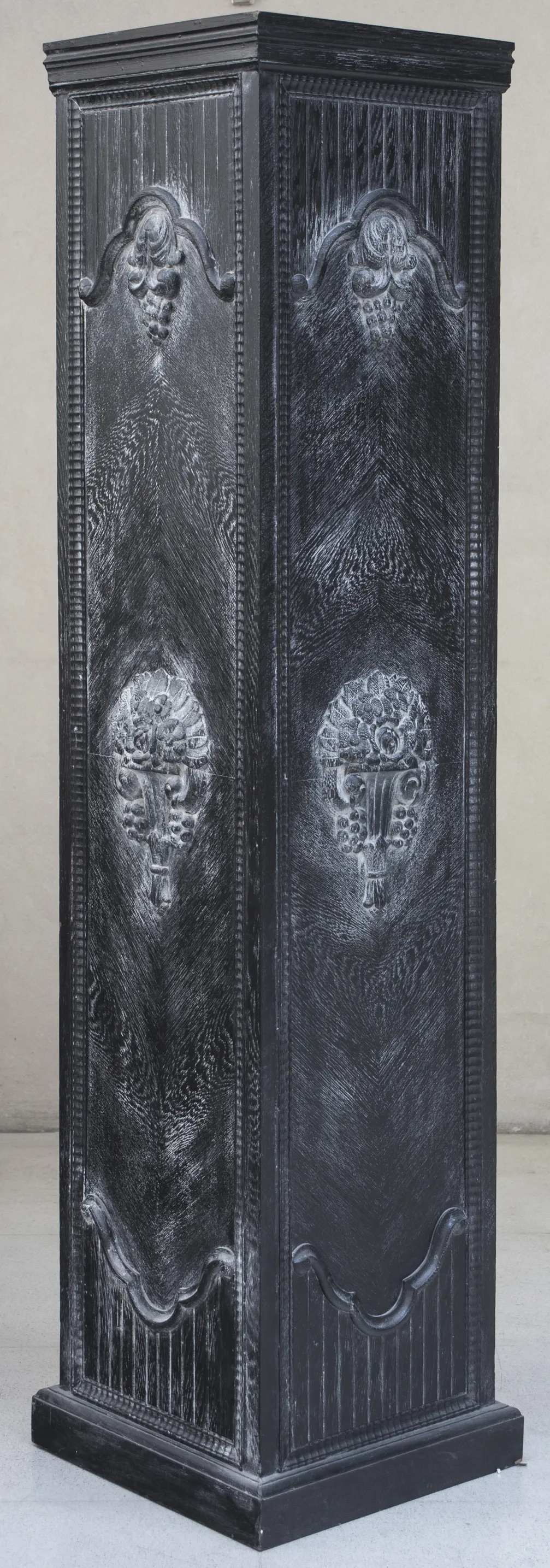 columna antigua negra con tallas detalle de uvas