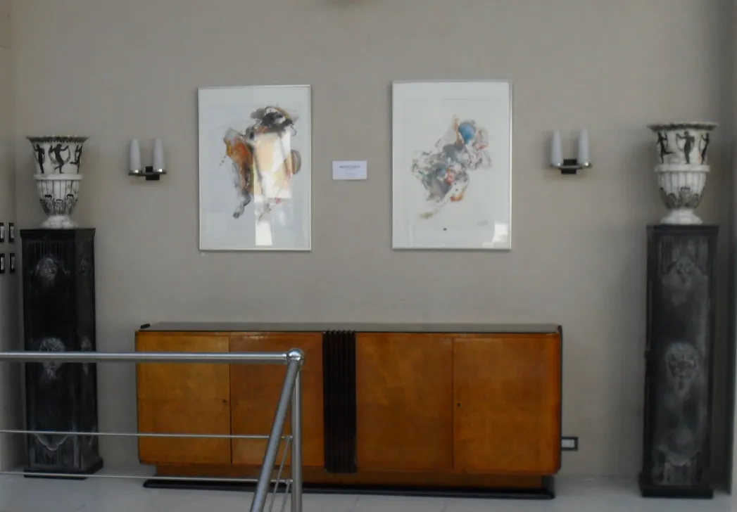 Coluna antiga decorativa ao lado de obras de arte modernas