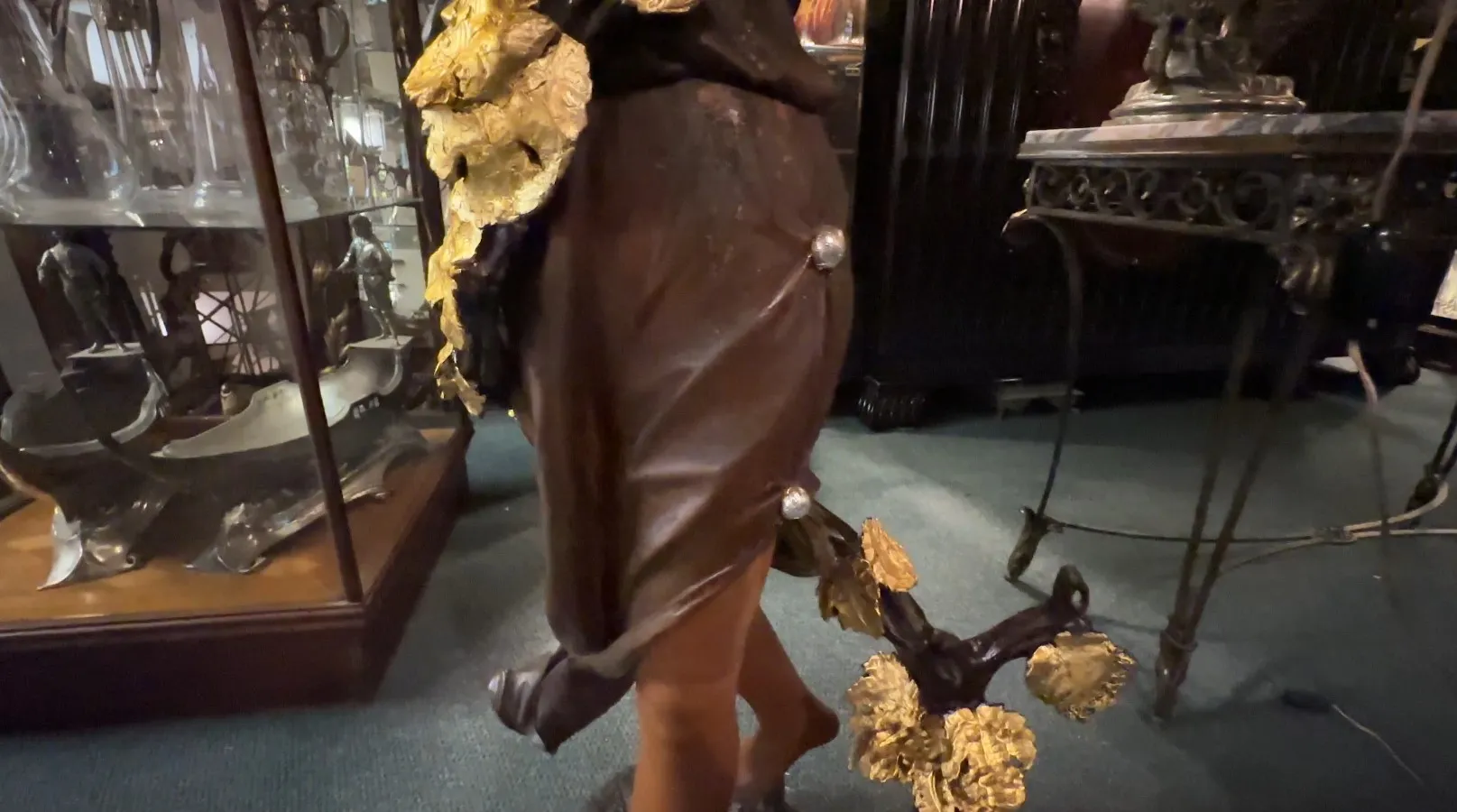 Escultura antiga decorativa com detalhes dourados em um ambiente clássico.