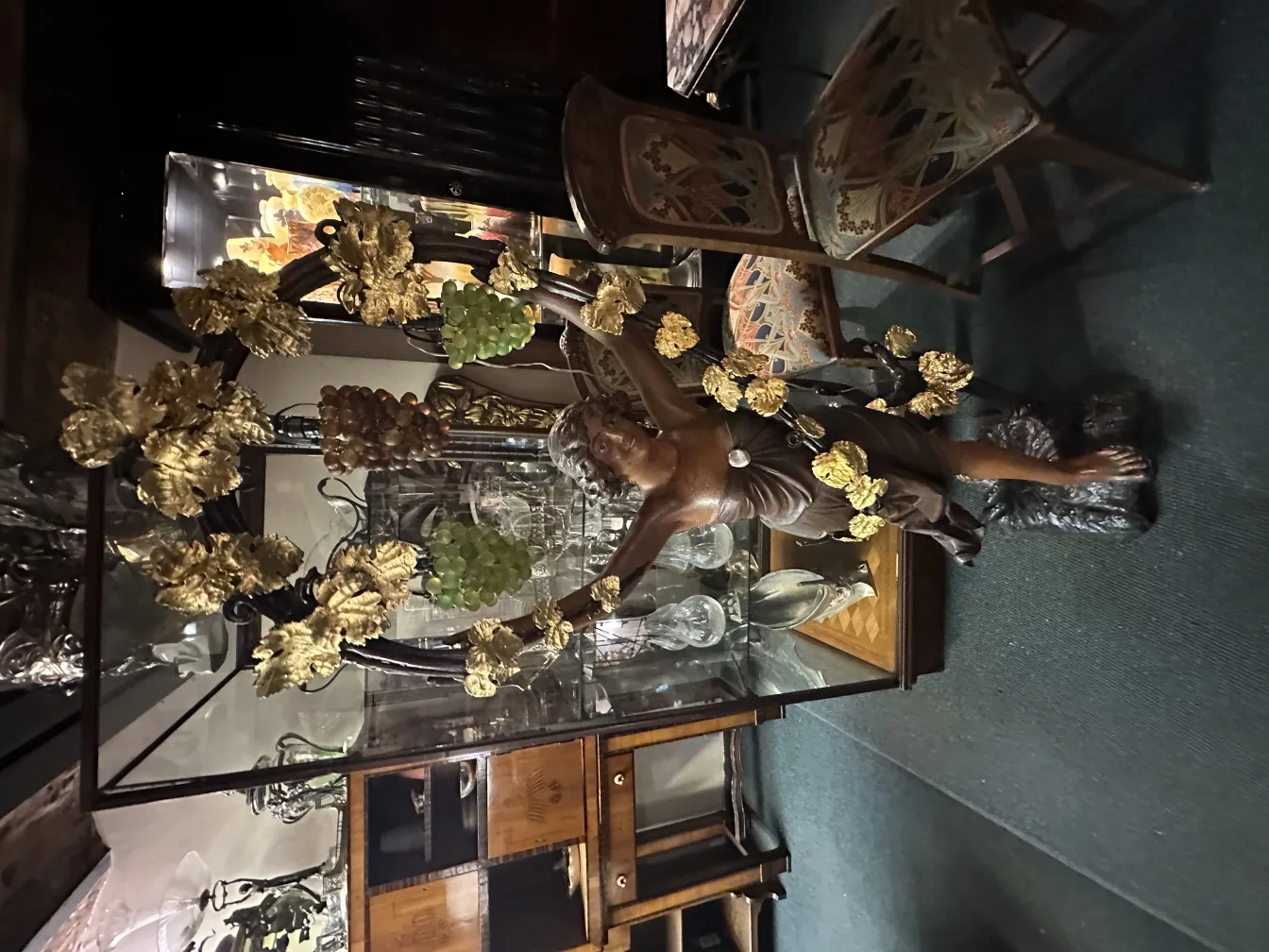 scultura antica decorativa di una figura con foglie dorate su sfondo di antiquariato