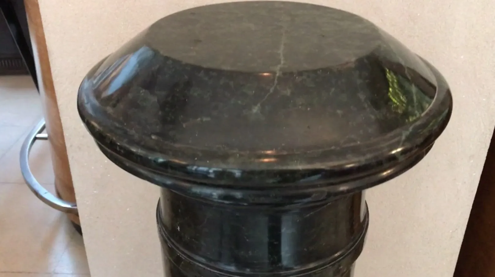 Columna antigua decorativa con cabeza redondeada, ambiente cálido.