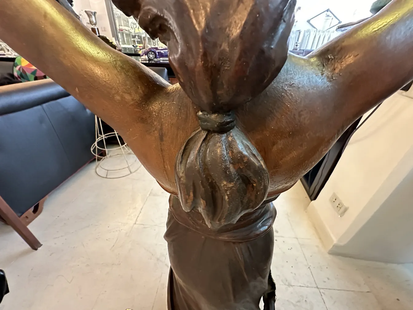 Sculpture ancienne avec figure humaine dans un cadre artistique.