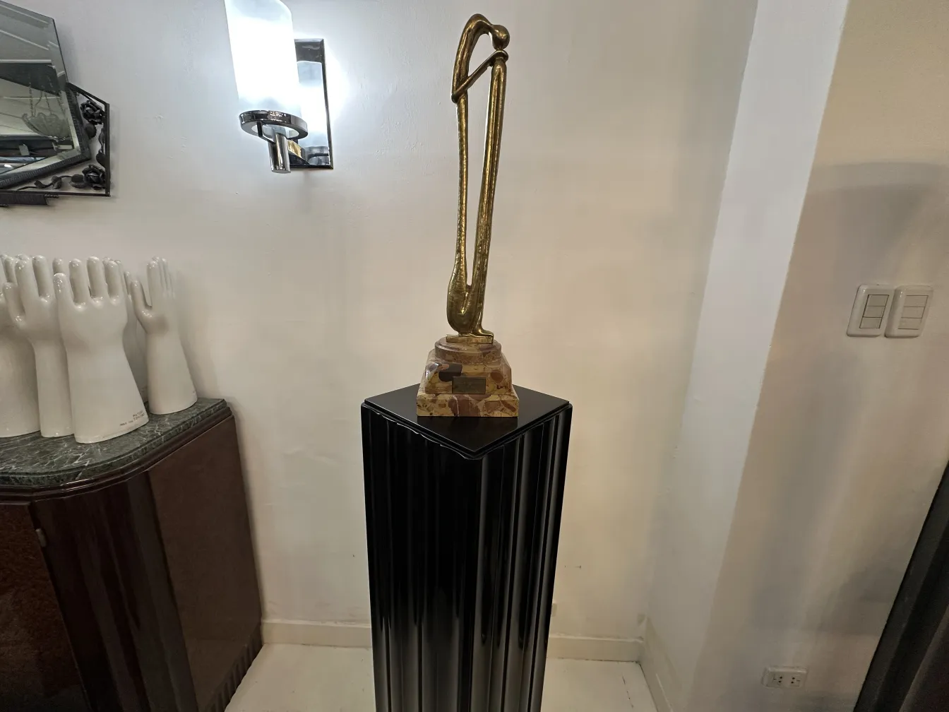 Antike dekorative Säule mit einer Statue oben, umgeben von einer eleganten Umgebung.