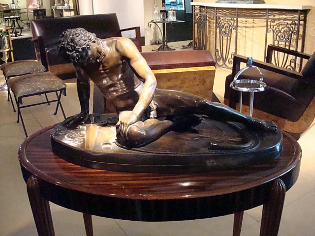 antique sculpture depicting a male figure at rest