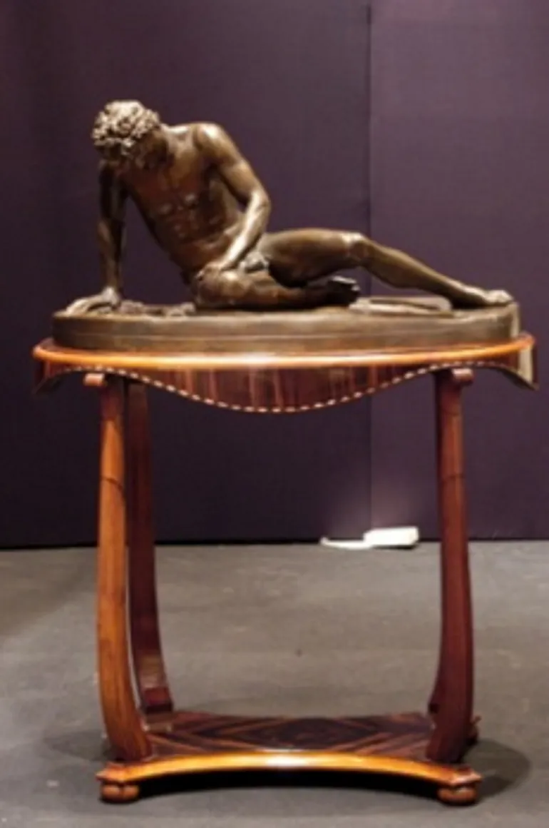 sculpture ancienne avec figure masculine allongée sur table