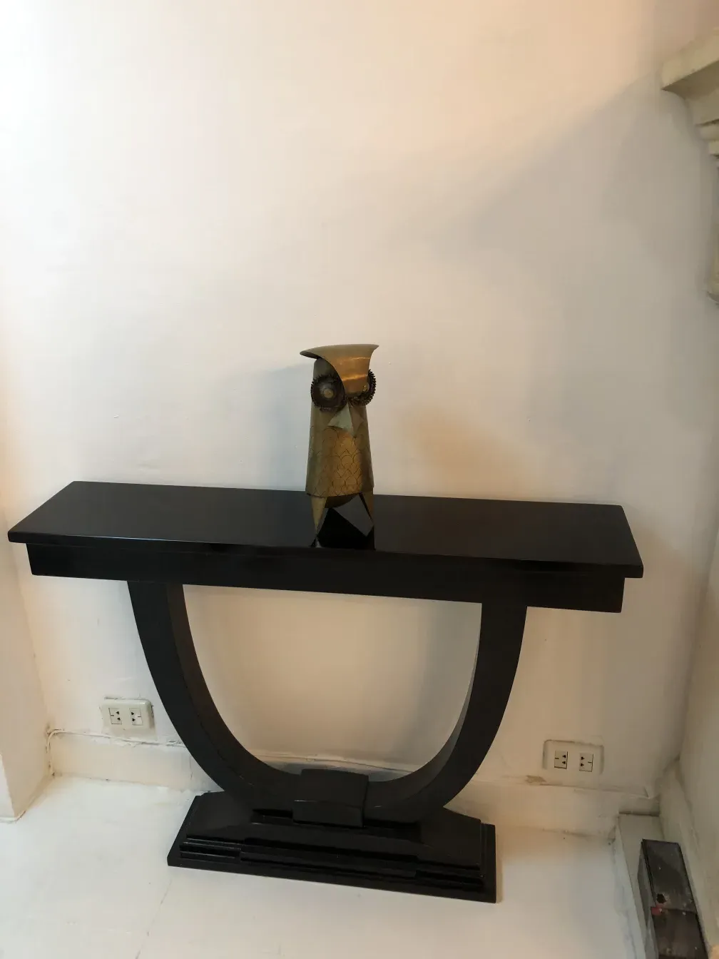 Scultura antica di gufo su un tavolo nero