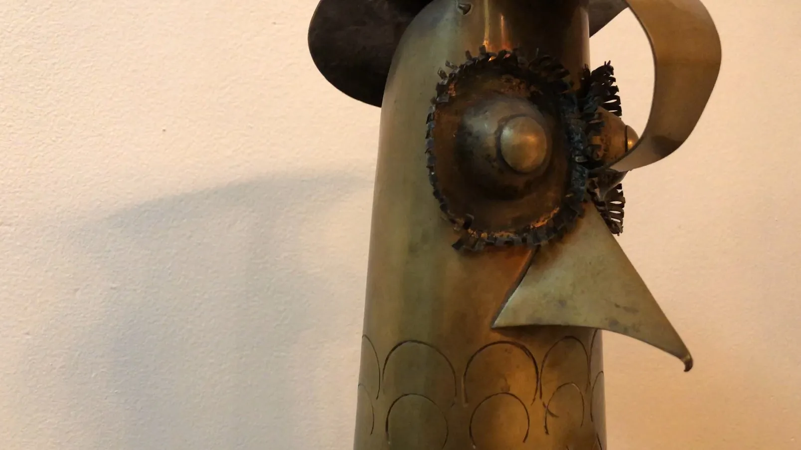 scultura antica a forma di testa con dettagli decorativi in metallo