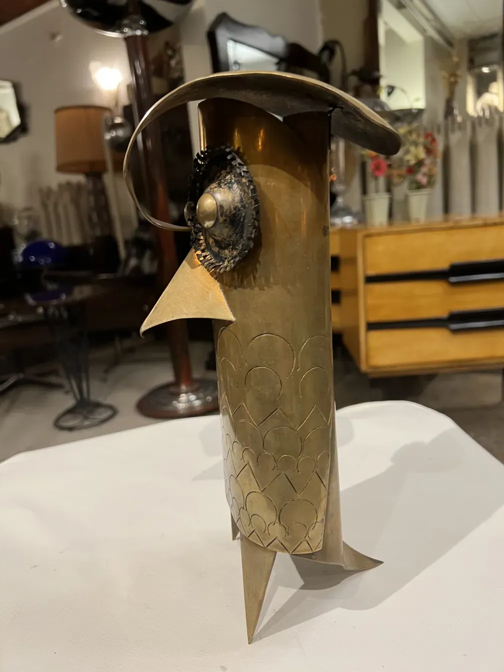 escultura metálica com formas abstratas e detalhes decorativos em um ambiente antigo