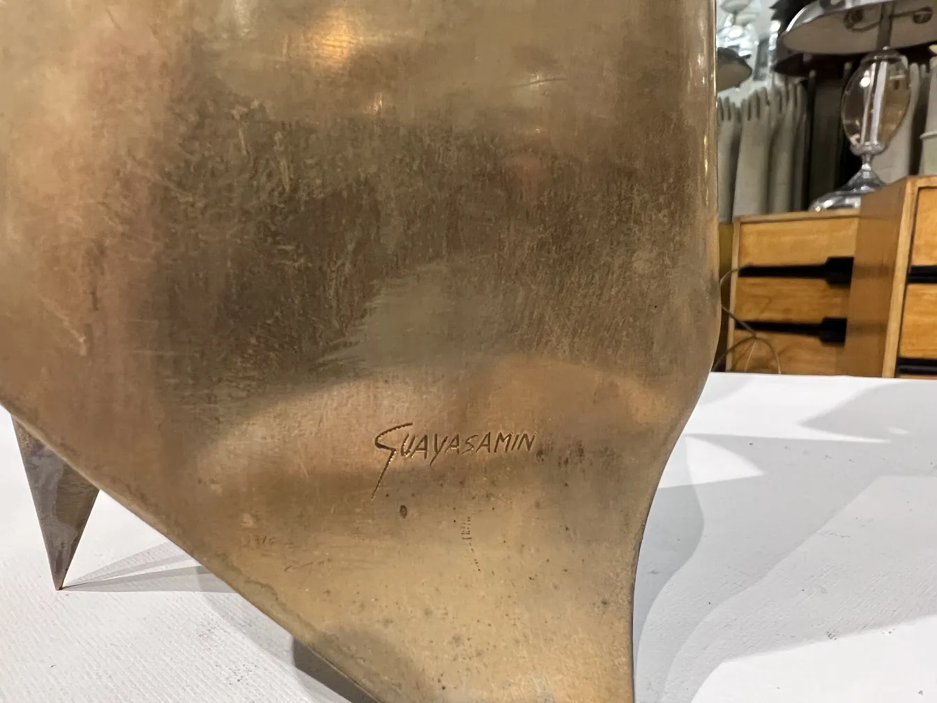 Antike Skulptur mit der Unterschrift von Oswaldo Guayasamín und organischen Formen.