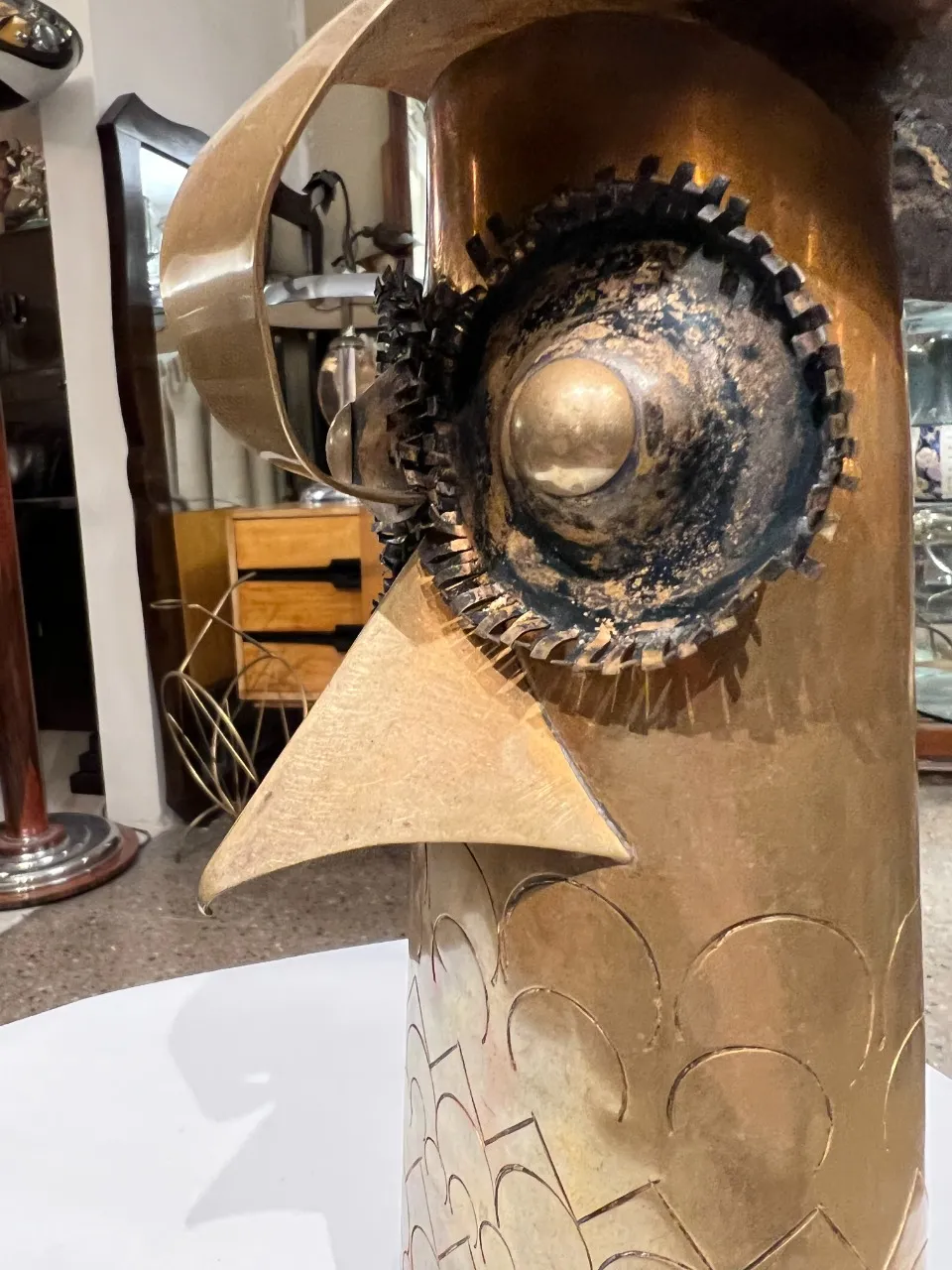 Antique sculpture featuring an abstract design and unique shapes. Decorative elements are visible in the background.