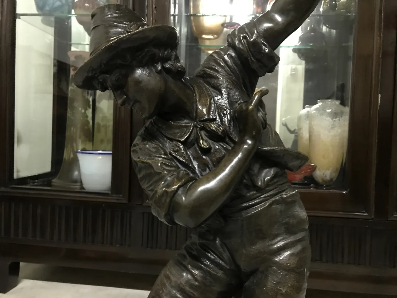 escultura antigua de figura masculina con sombrero y gesto