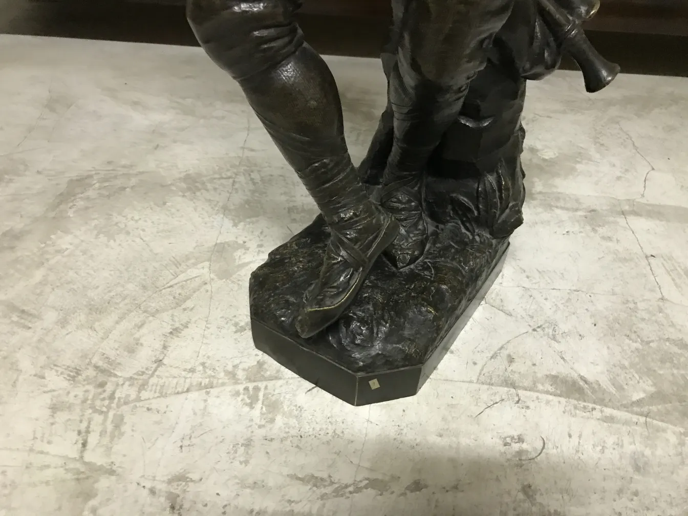 Escultura antiga com detalhes decorativos finos na base.