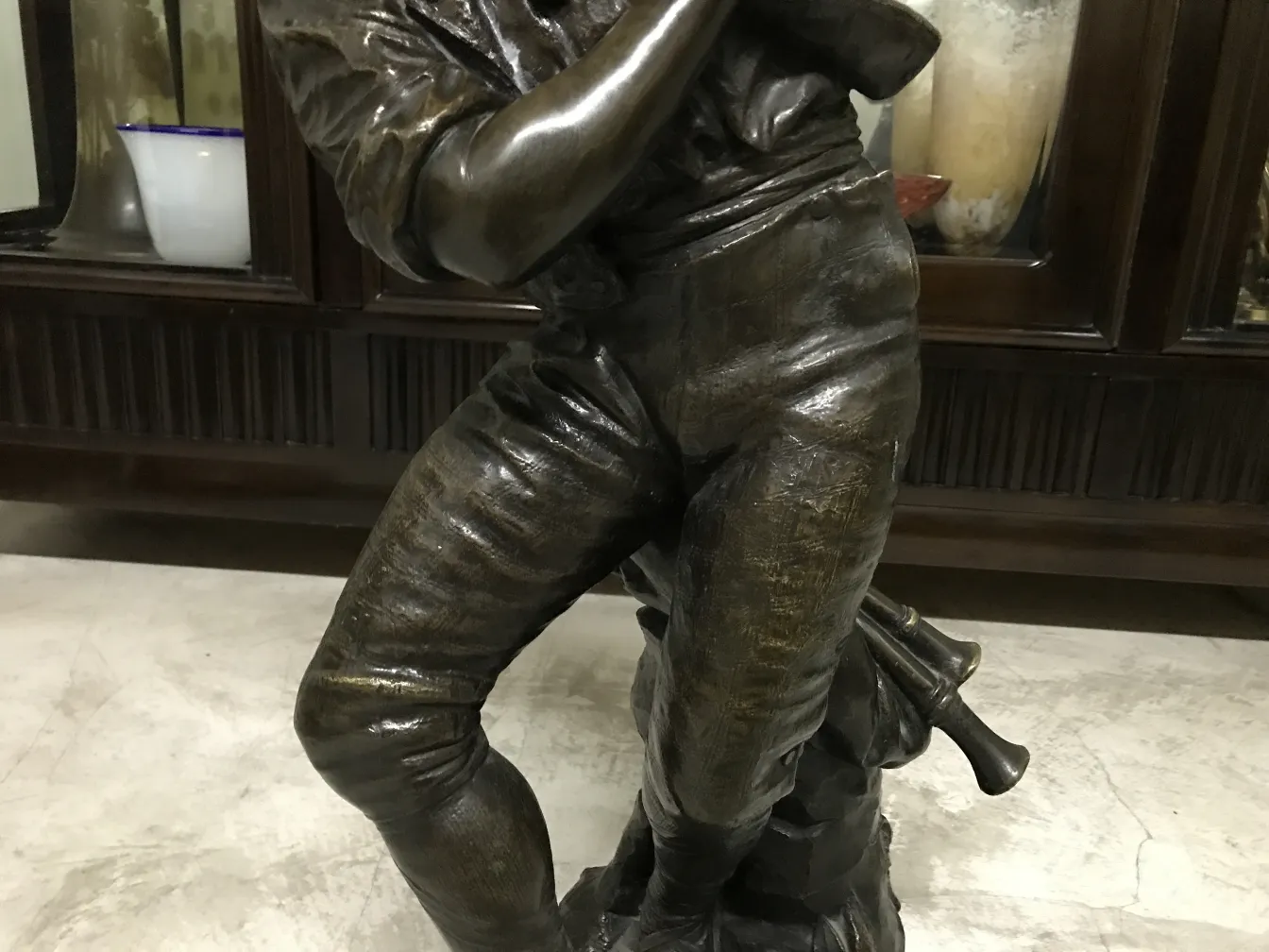 Escultura antiga com figura humana, detalhes realistas, contexto elegante.