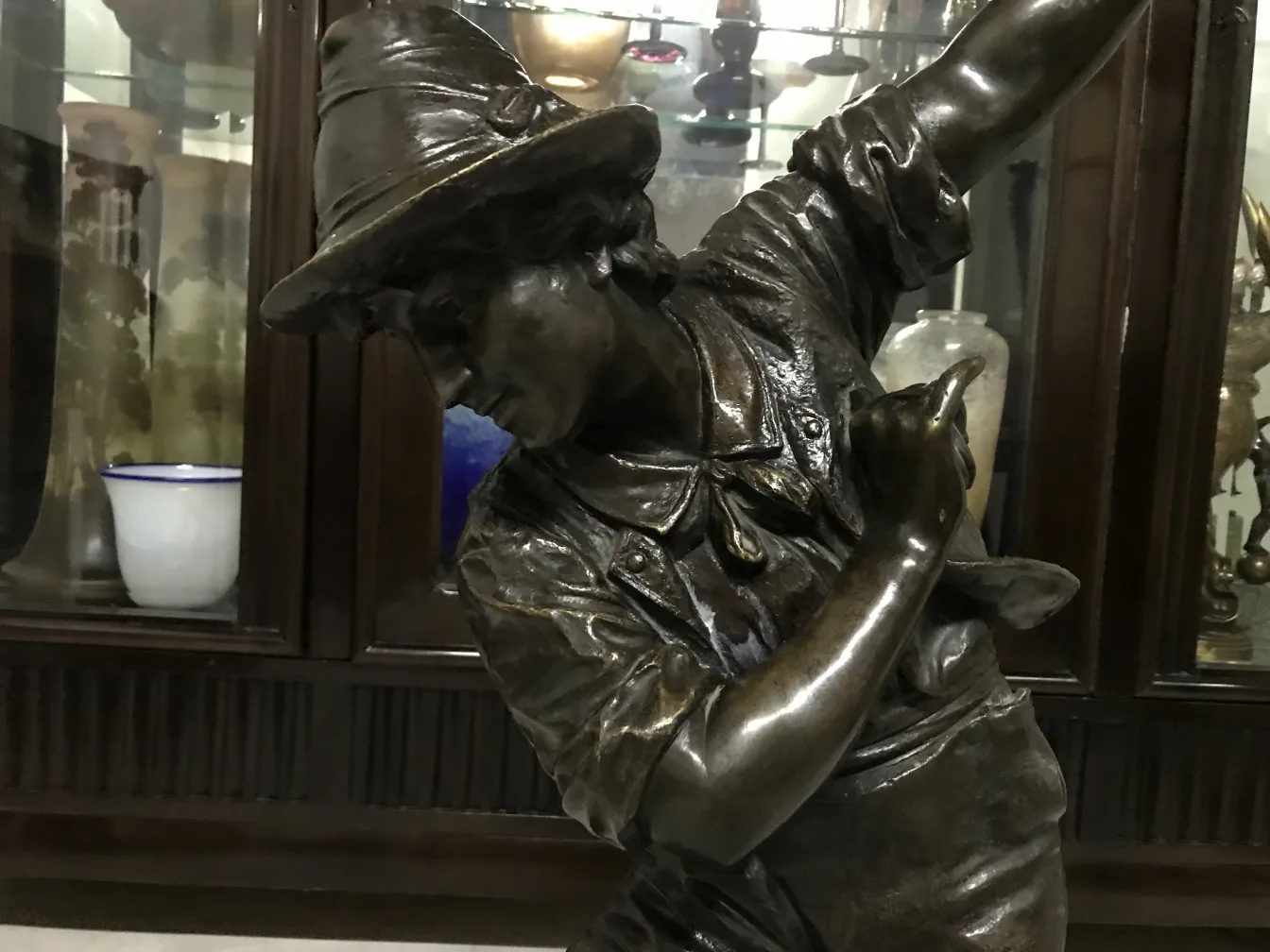 scultura antica di un uomo con cappello e gesto