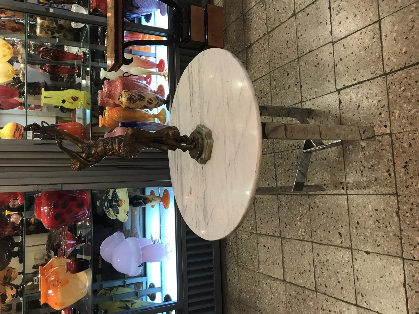 scultura antica su un tavolo con decorazioni in vetro sullo sfondo