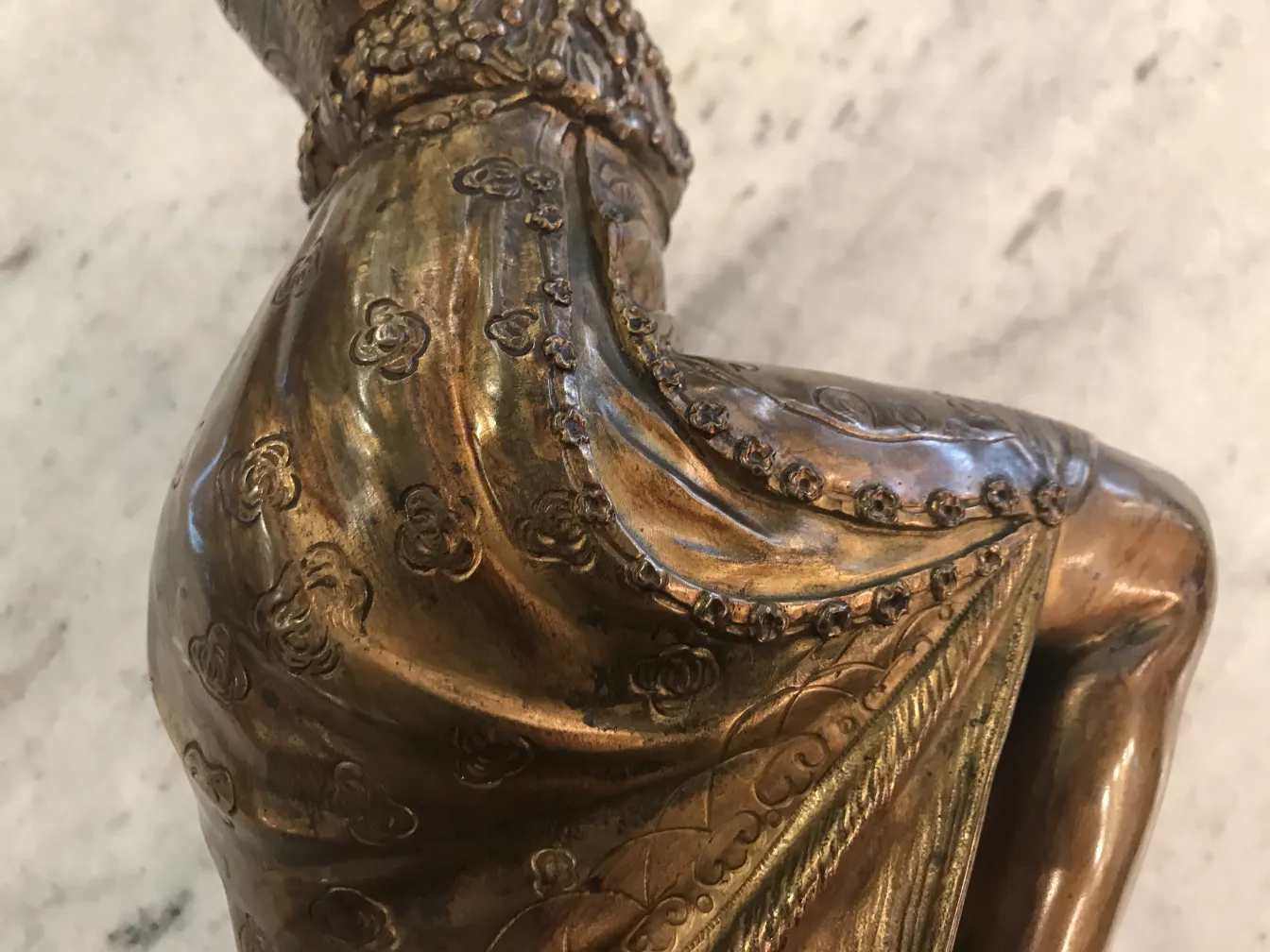 scultura antica che rappresenta una figura con dettagli ornamentali