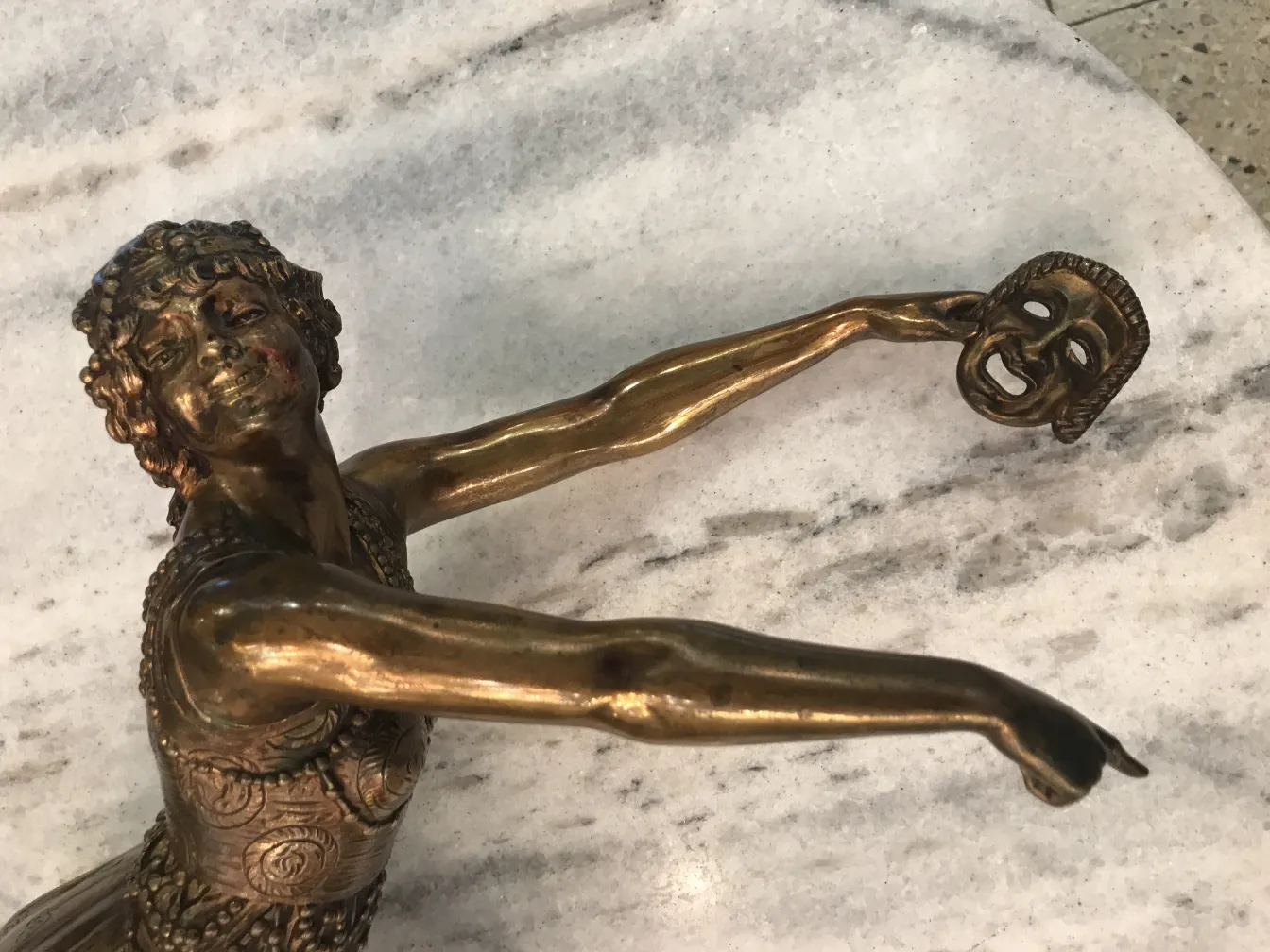 escultura antiga com figura humana e máscara teatral