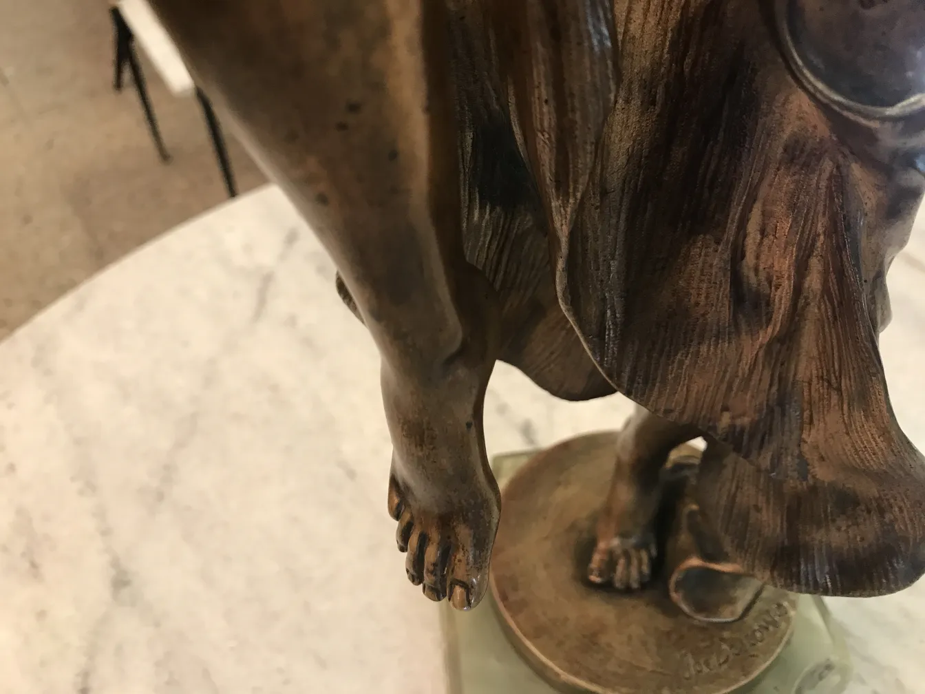 Escultura antiga com detalhes visíveis e base decorativa.