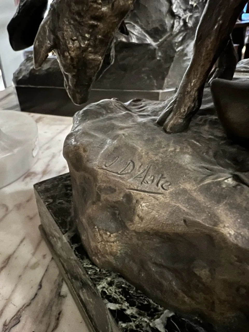 Escultura antigua con detalles como una firma, ambiente acogedor