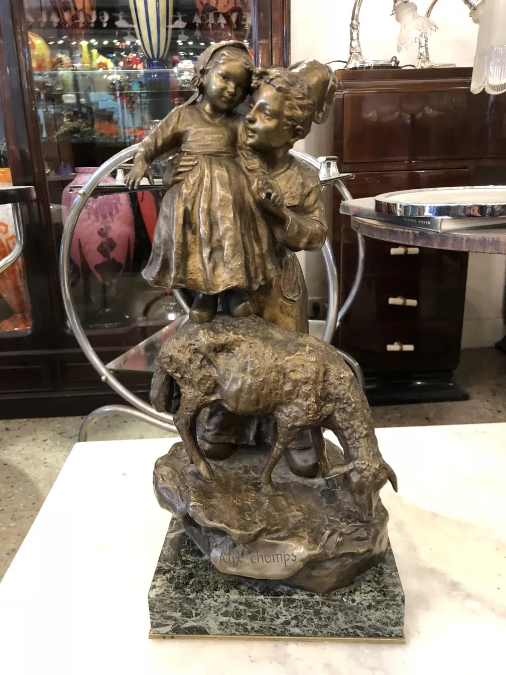 Escultura antiga de Giuseppe D'aste com menino e menina, com animal ao fundo.