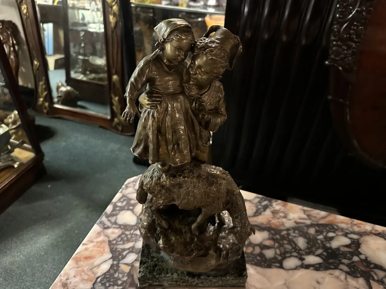 scultura antica di bambini che si abbracciano in un paesaggio