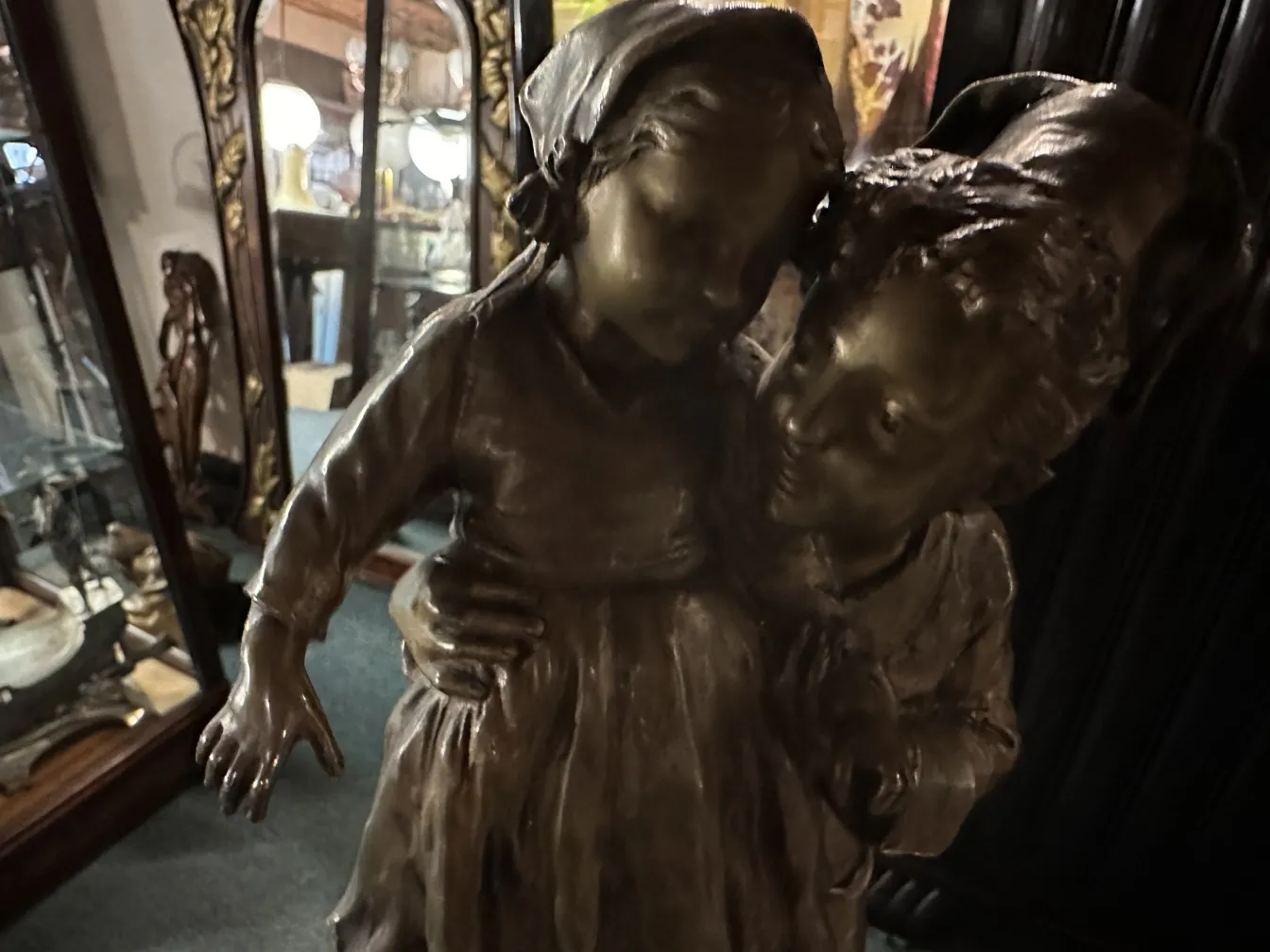 antike Skulptur mit zwei umarmenden Figuren in einer Vintage-Umgebung