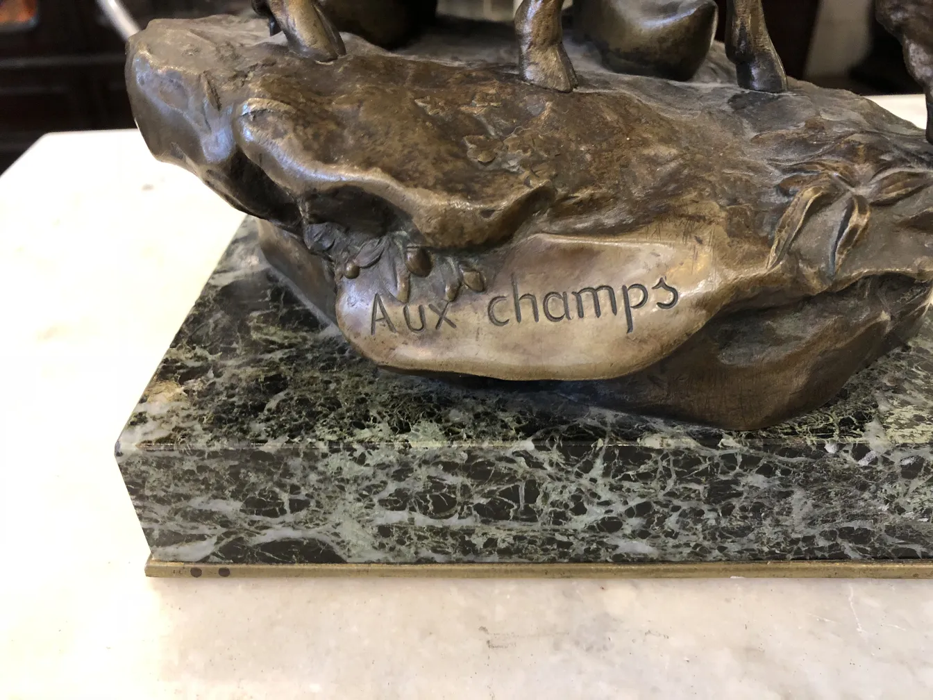 sculpture ancienne en bronze avec signature visible et base décorative