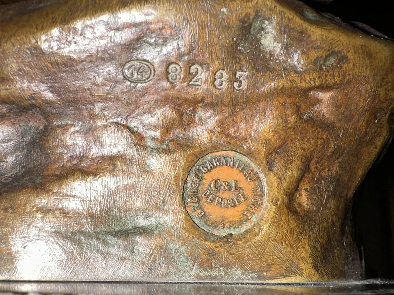 escultura antigua con detalles interesantes y firma