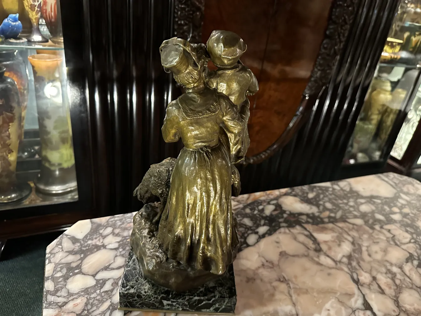 scultura antica con dettagli dorati, che rappresenta donne e bambini