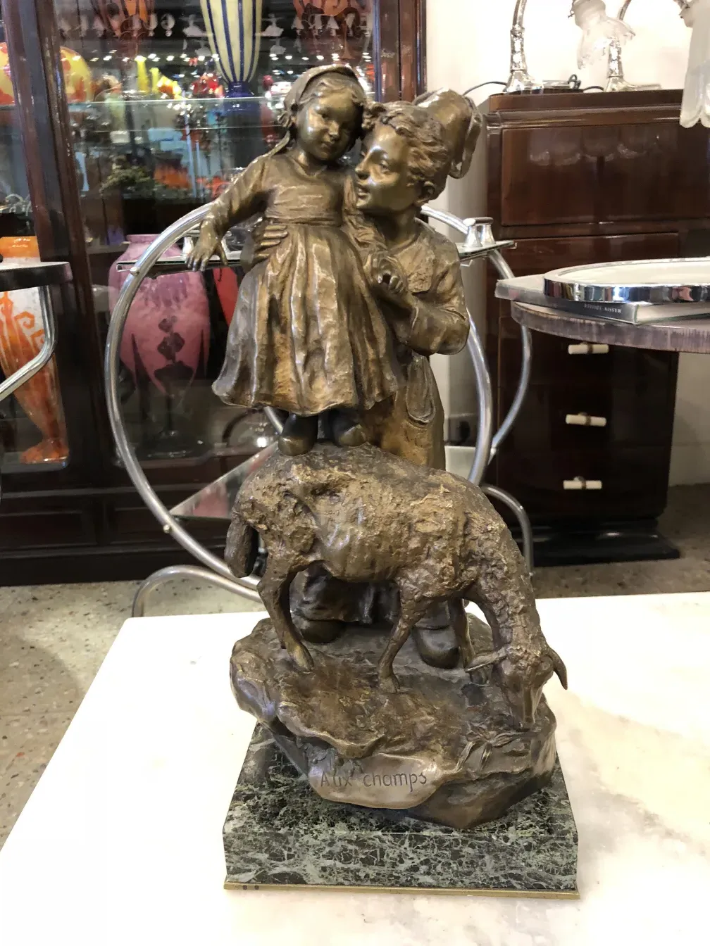 antique sculpture depicting a child and an animal in a landscape