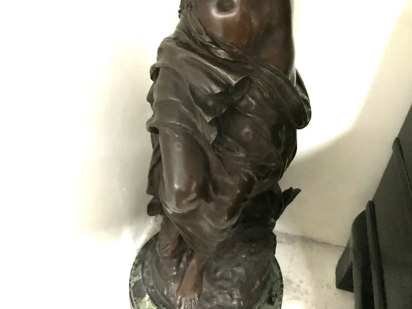 sculpture ancienne d'une figure debout, avec des détails sur les vêtements