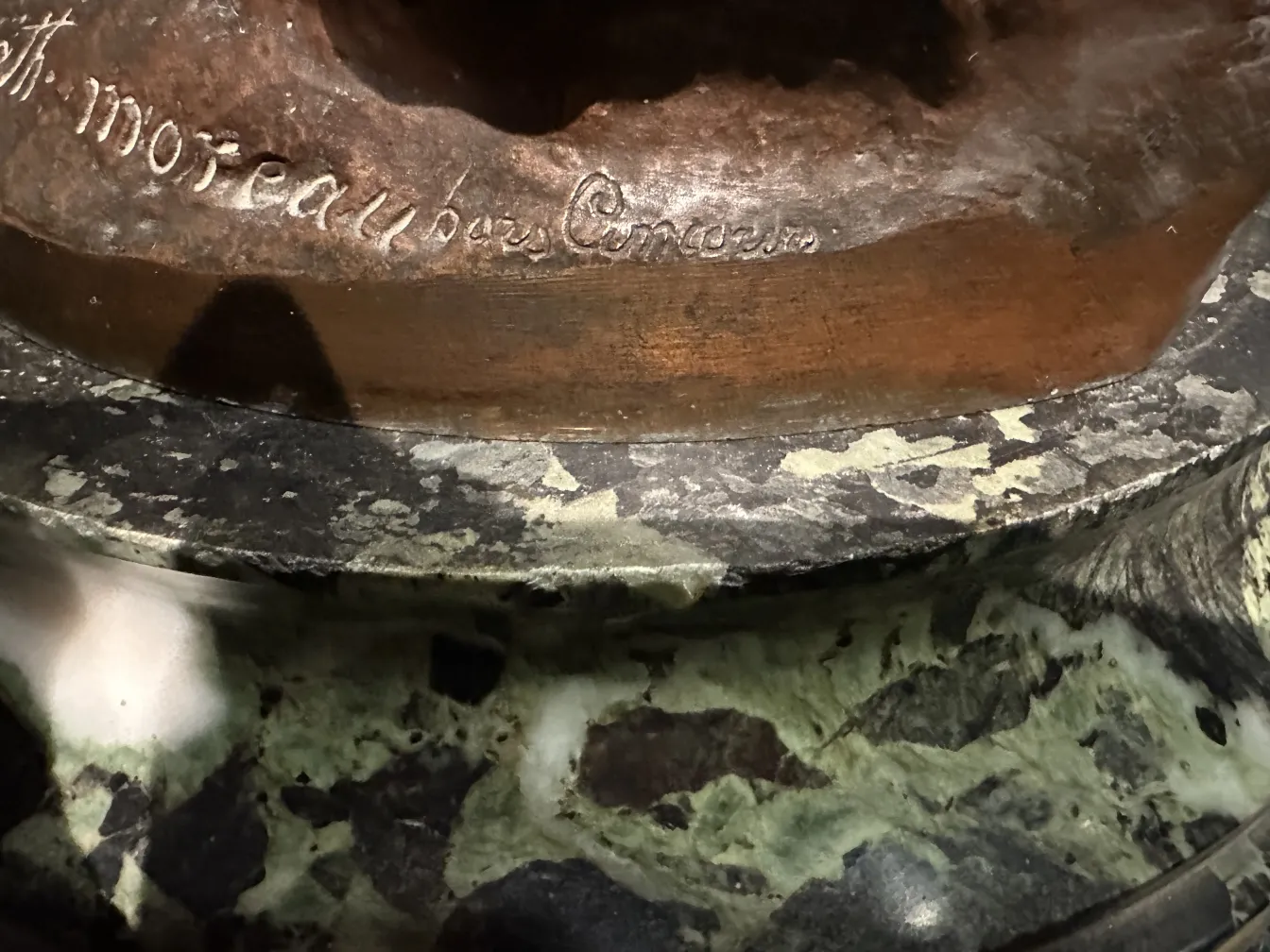 escultura antiga com base detalhada e fundo escuro