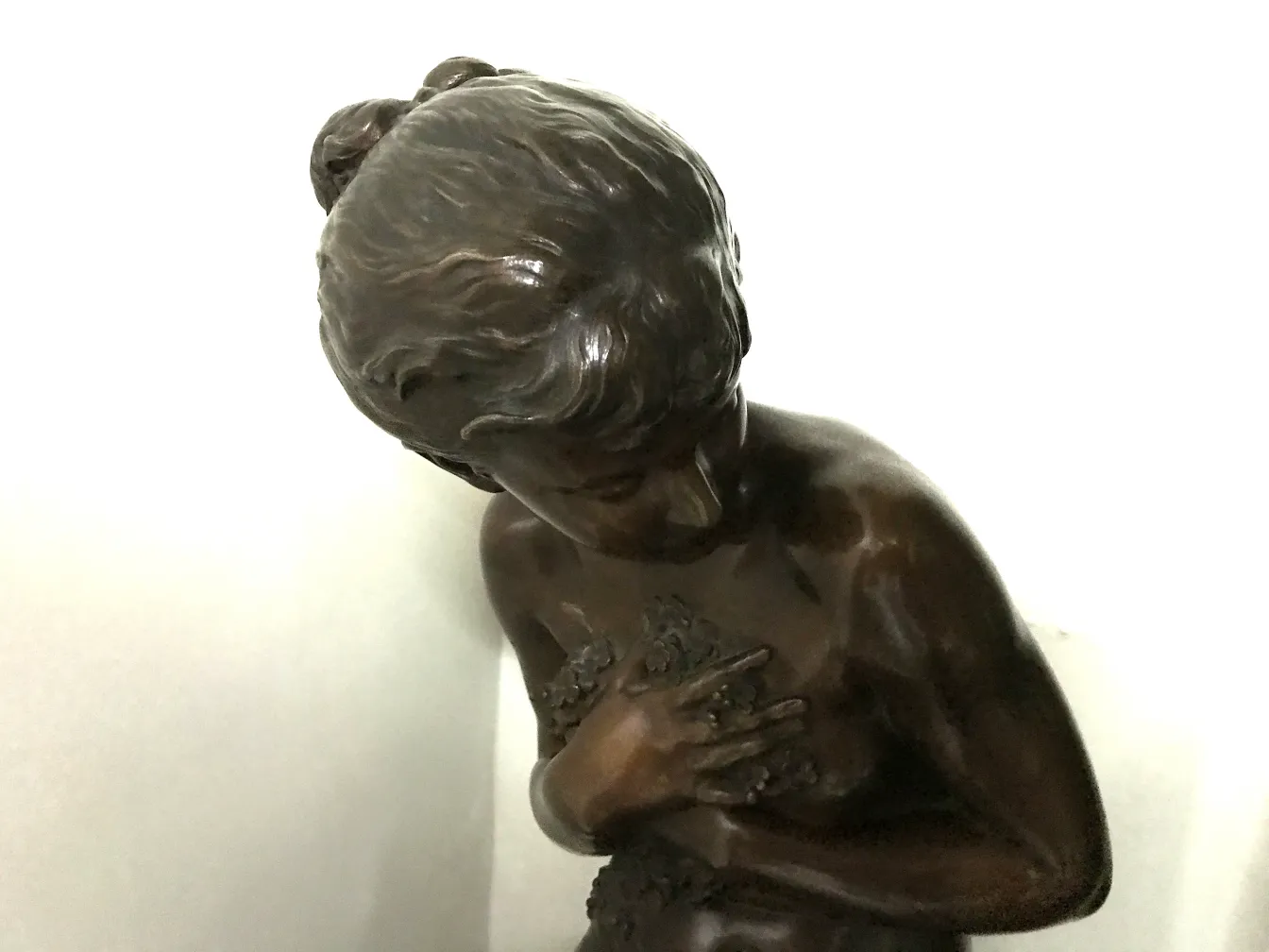 scultura antica con figura femminile in posa contemplativa