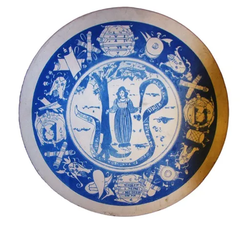 Prato de cerâmica antiga com desenho azul e branco, figura feminina central.