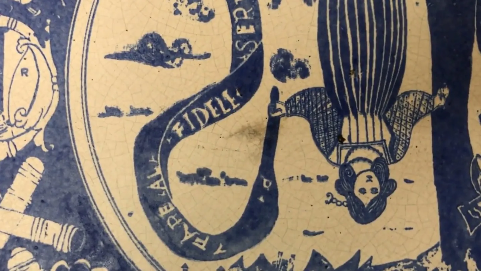 Céramique ancienne avec un design bleu et blanc, comportant des figures ornementales