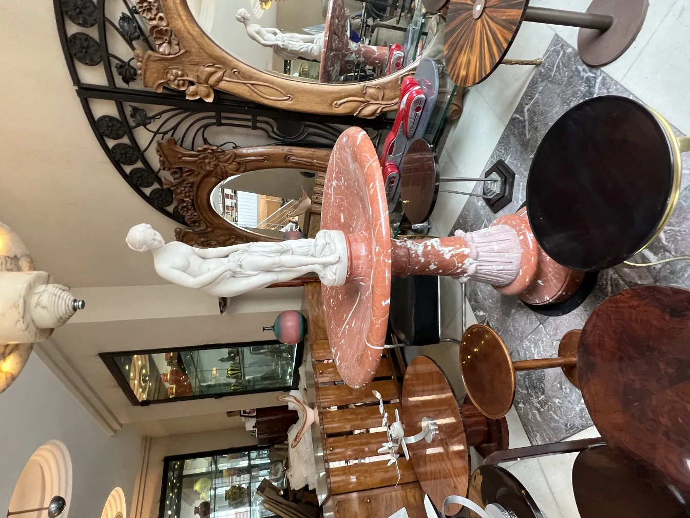 escultura branca de figura humana em pedestal de mármore em ambiente elegante