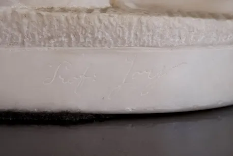 Antike Skulptur mit sichtbarer Inschrift an der Basis.