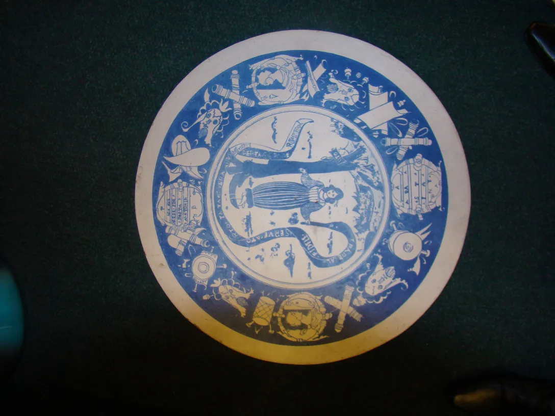 Plato de cerámica antigua con diseños en azul y blanco, ambiente elegante con fondo verde.