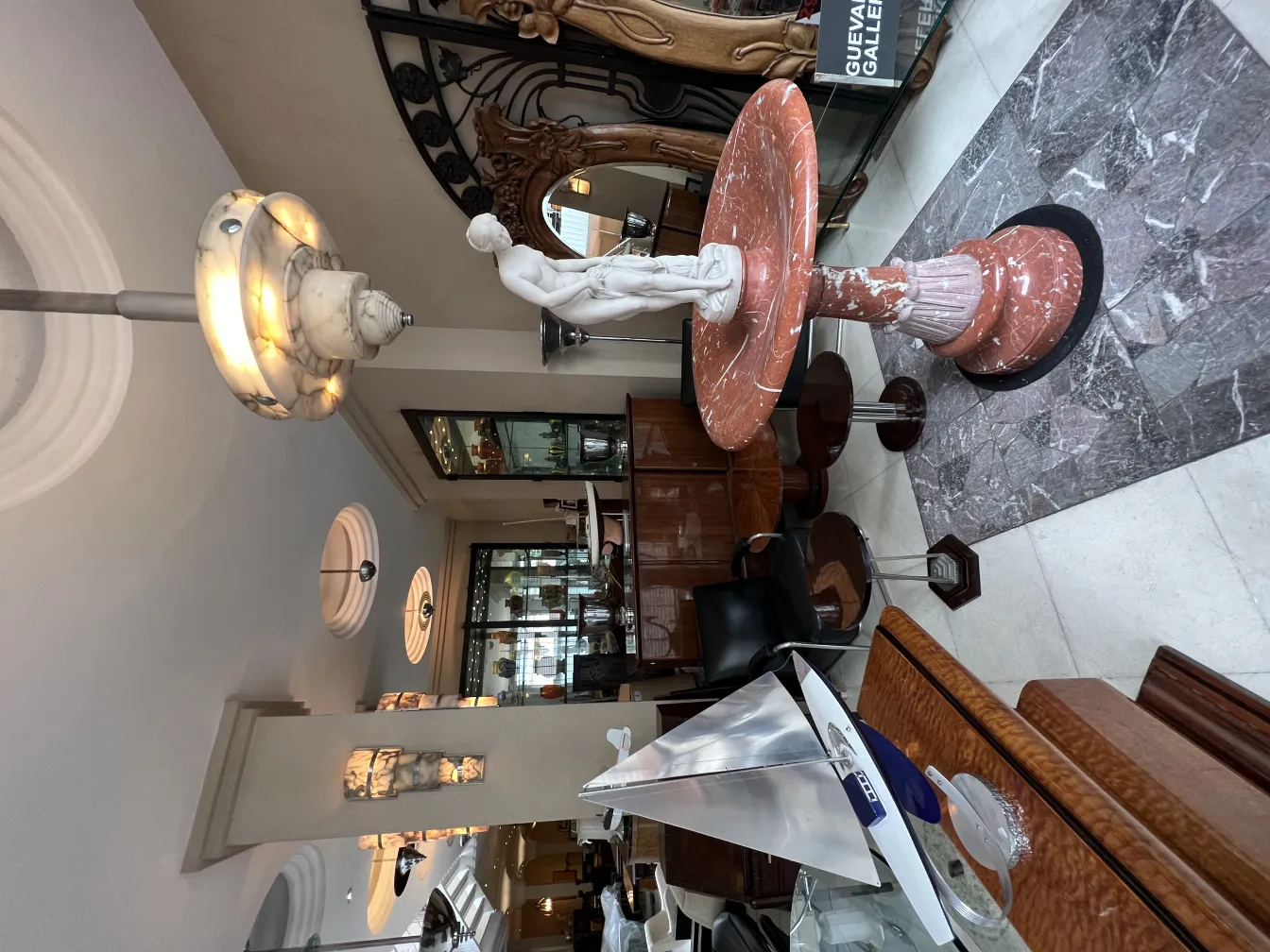 تمثال قديم من الرخام في غرفة أنيقة مع مصباح