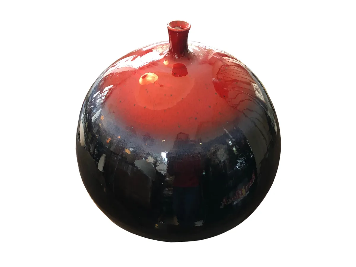 Ceramica sferica decorativa brillante in rosso e nero, ideale per l'esposizione.