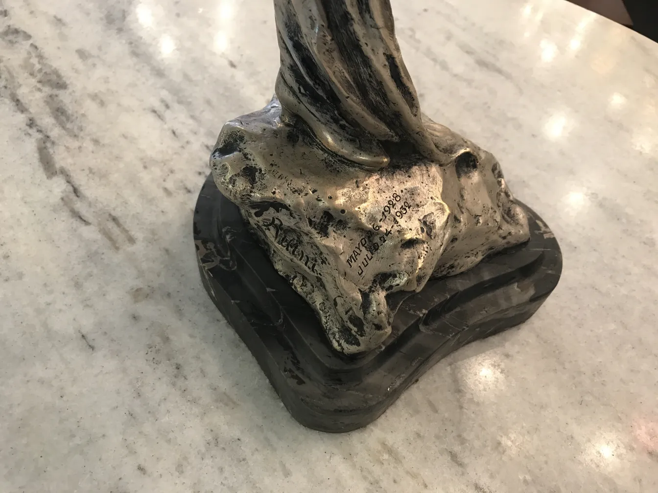 Antique sculpture featuring an intricate base and fine details.