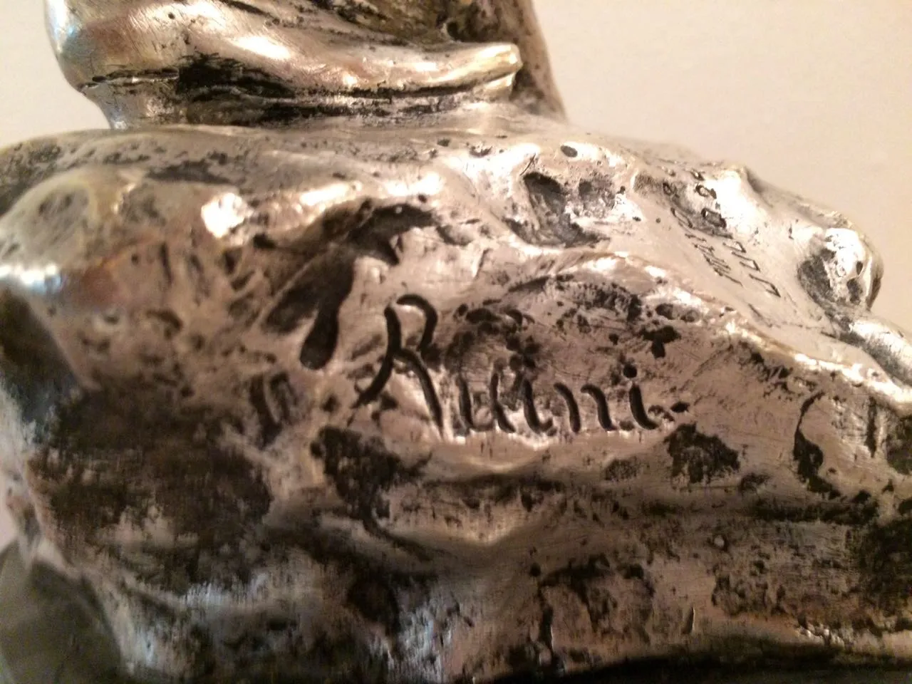 Sculpture ancienne détaillée avec signature visible à la base.