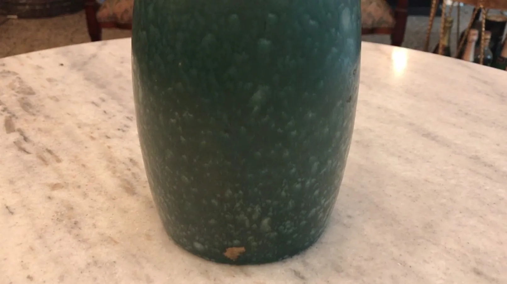 Antica ceramica verde con texture unica su un tavolo.