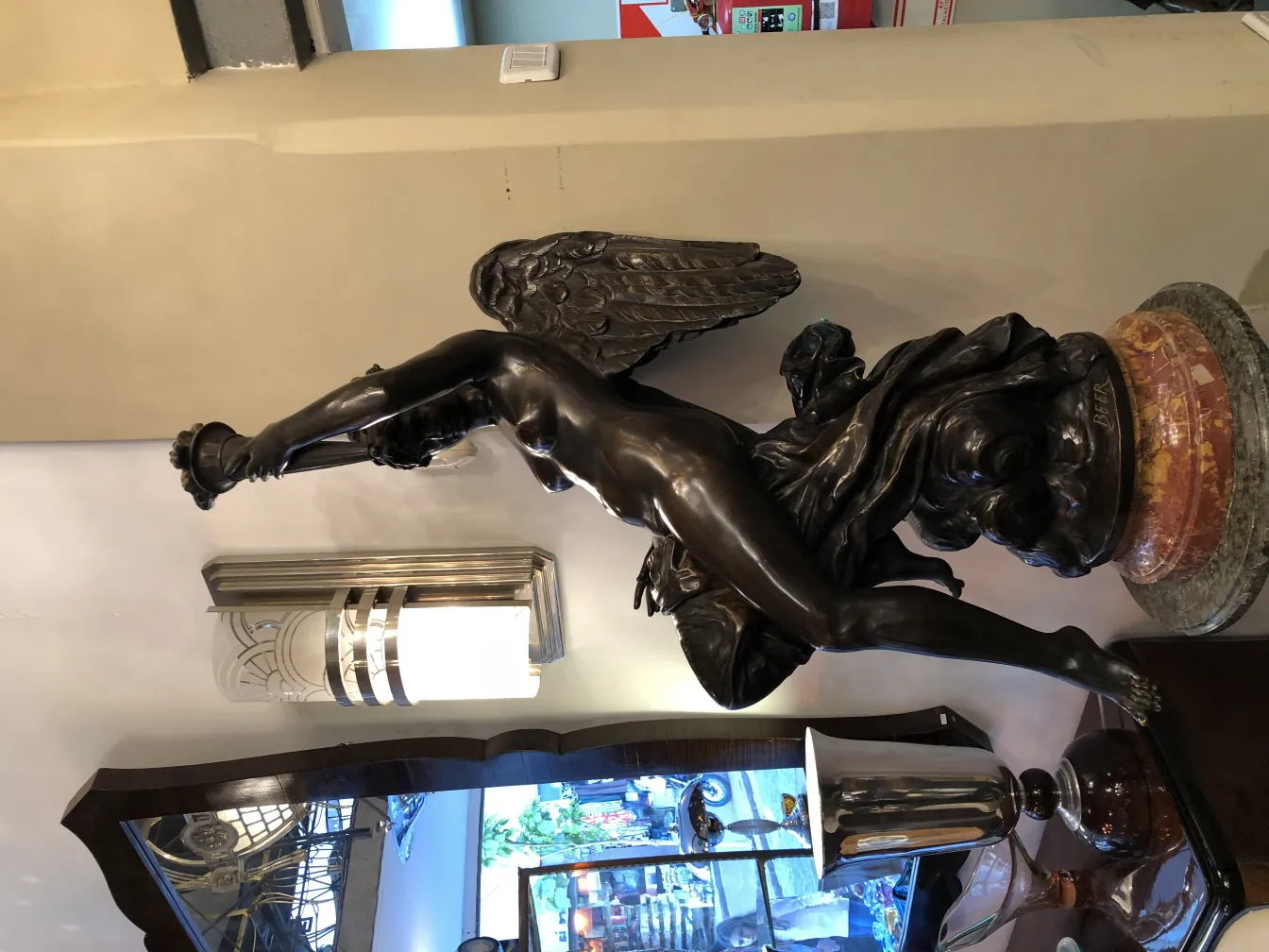 antique sculpture beer with wings and slender figure in a decorative setting