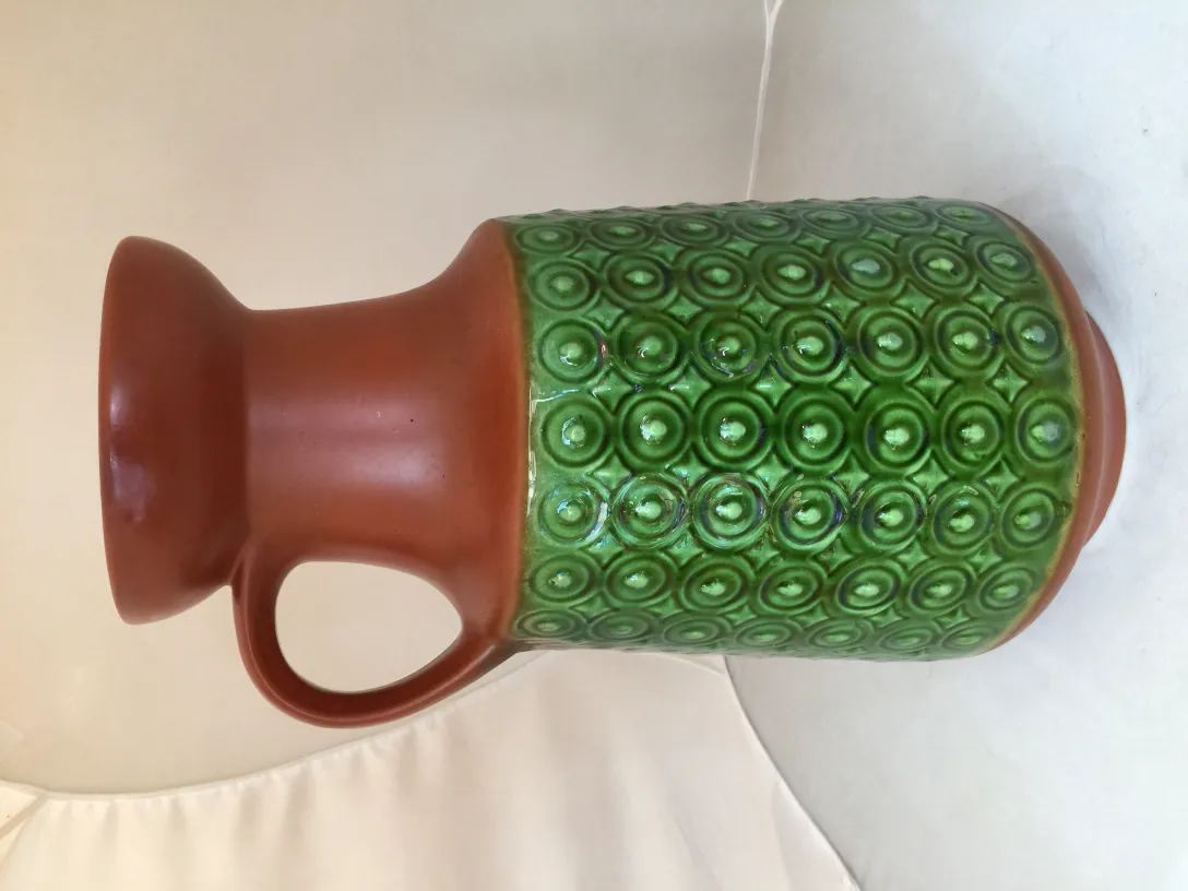 Vaso in ceramica antica con design verde e marrone.